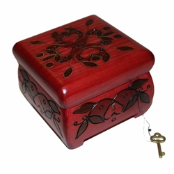 The cherry stained locking chest is perfect to lock away any special treasure.  The box is square in shape with rounded edges for a softer look.  It has 4 square feet that raise the box by 3/8". The top is ornamented with brass inlay and sides with a burn