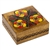 This wooden box is decorated with three bright, colorful flowers and three tulips. A circular design borders the sides of the box.