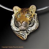 Tiger Pendant "I Am Tiger" by wildlife artist and jeweler Daniel C. Toledo, Toledo Wildlife Works of Art is created entirely by Dan in his studio in sterling silver and then plated in rhodium and 22k gold, black enamel, and peridot eyes.